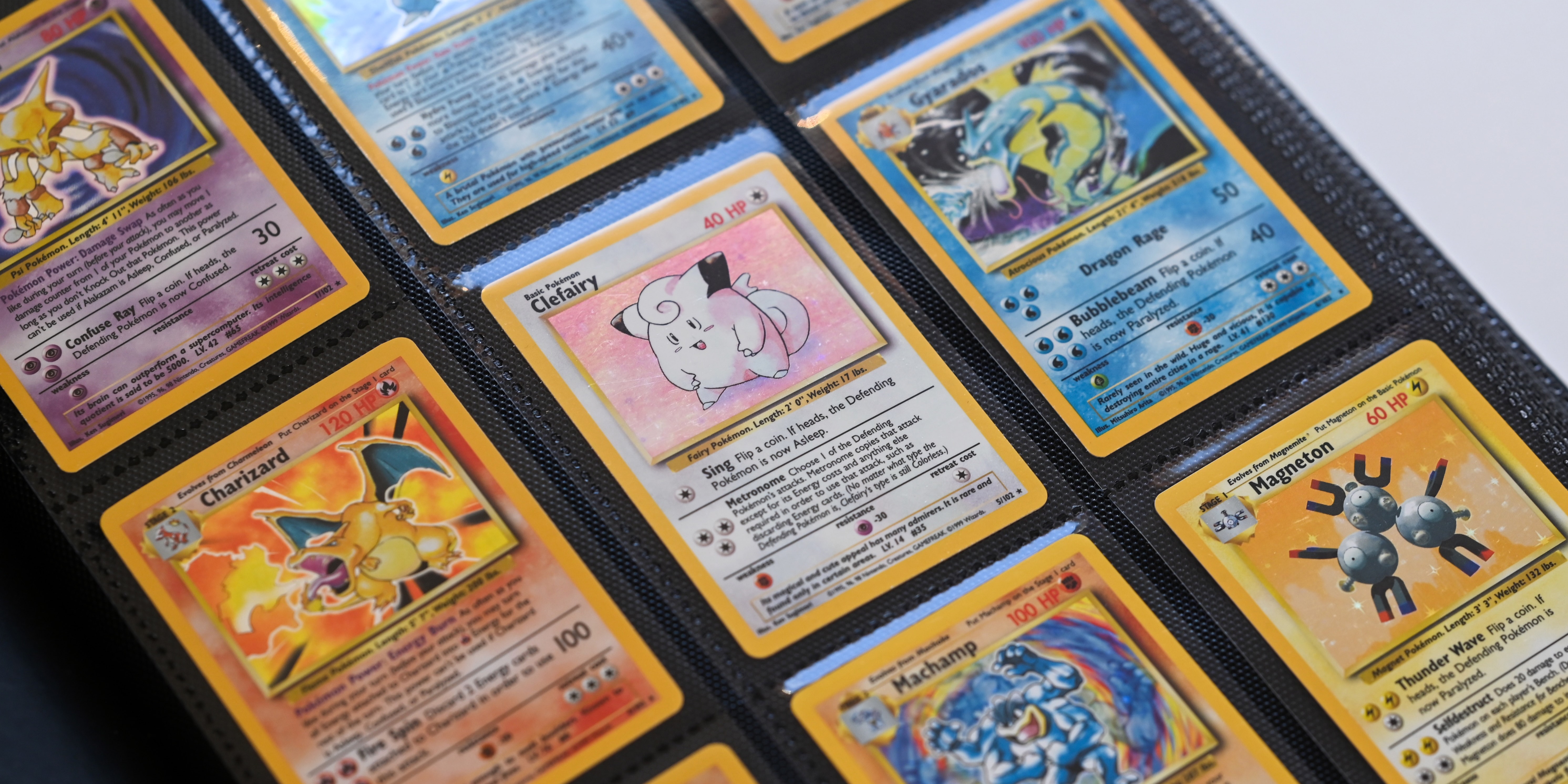 Classeur de cartes Pokémon anciennes, avec notamment Dracaufeu, Mélofée, Léviator et Magnéton.